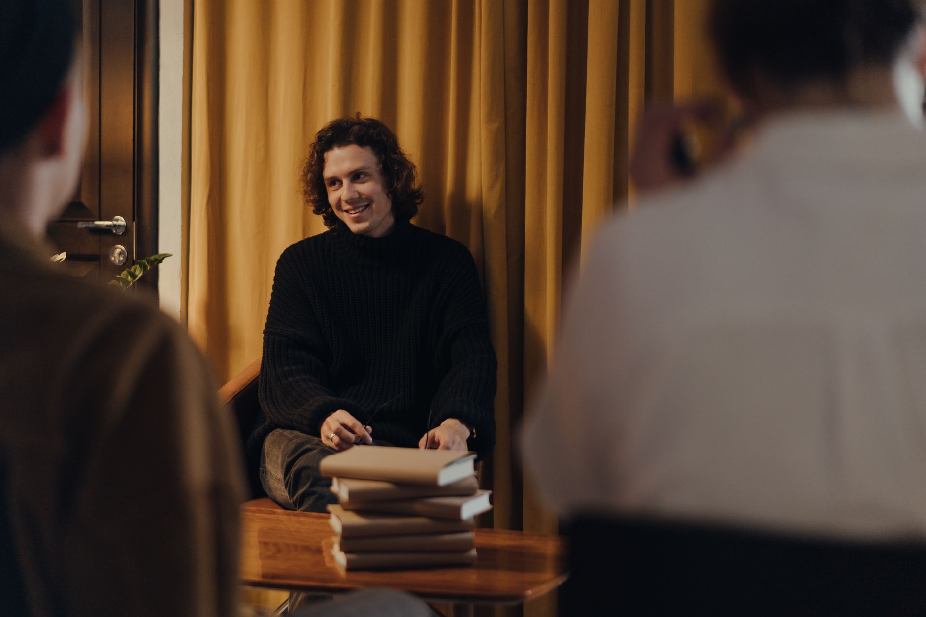 A writer discusses his book with an audience during a creative evening at a cozy bookstore.