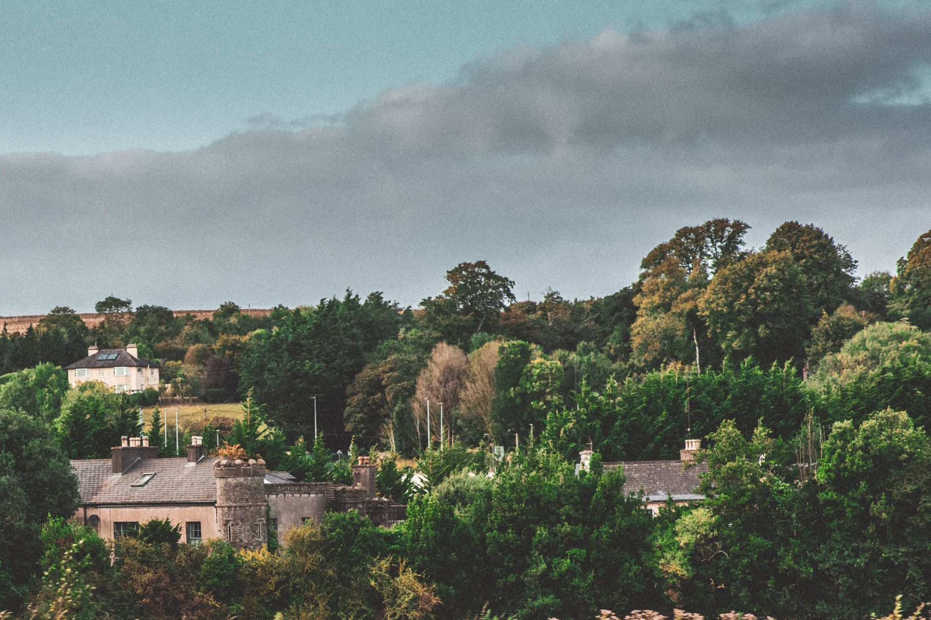 Picturesque view of historic buildings amidst lush greenery in Cork, Ireland.