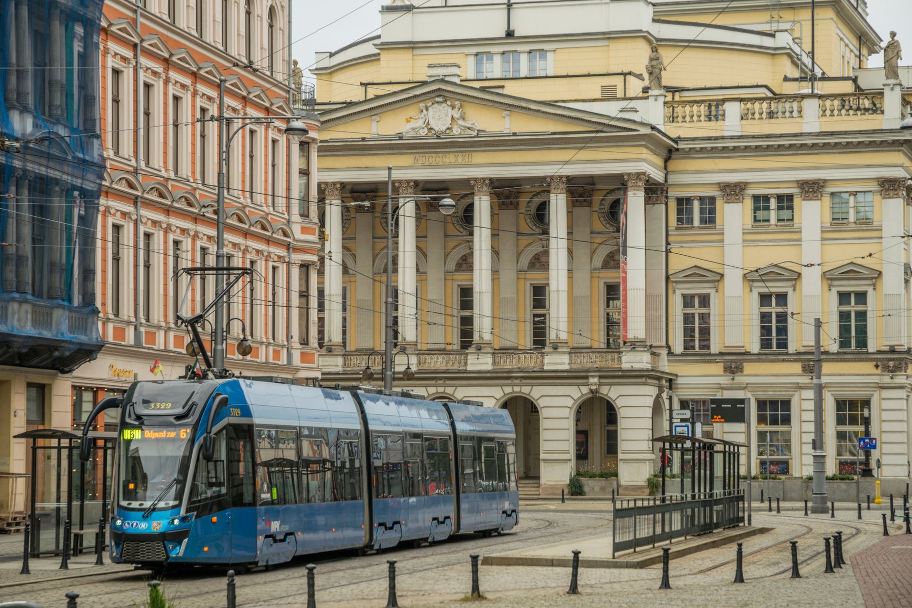 A city tram moves through Wrocław, showcasing its vibrant urban life and historic architecture.
