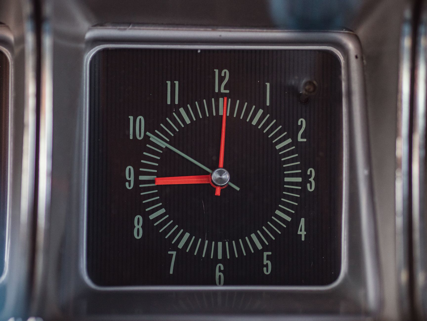 Close-up of a vintage 1966 Chevrolet Caprice dashboard clock showcasing retro design.