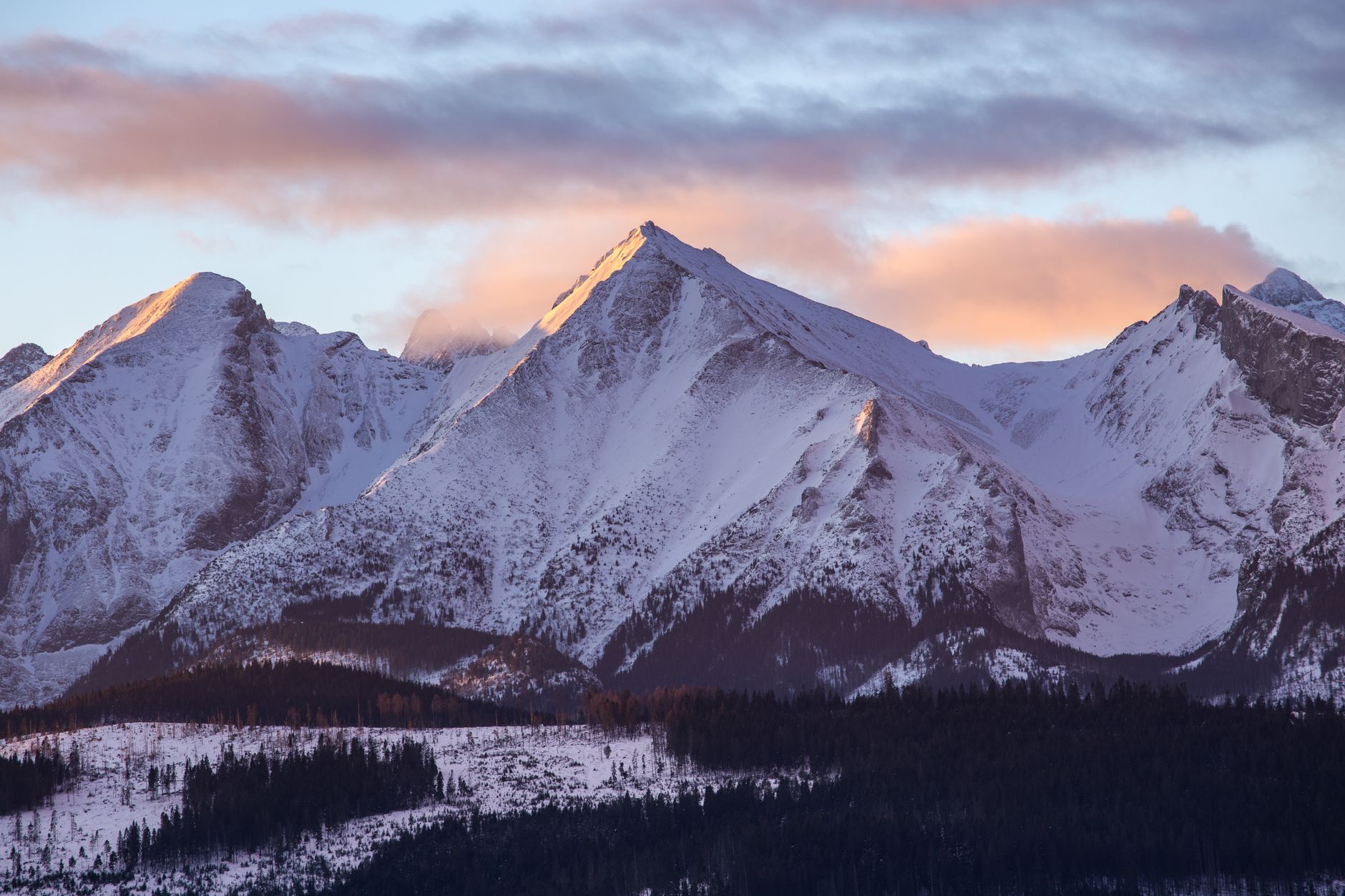 Captivating view of the Tatra Mountains in Poland with snow-covered peaks at sunset.