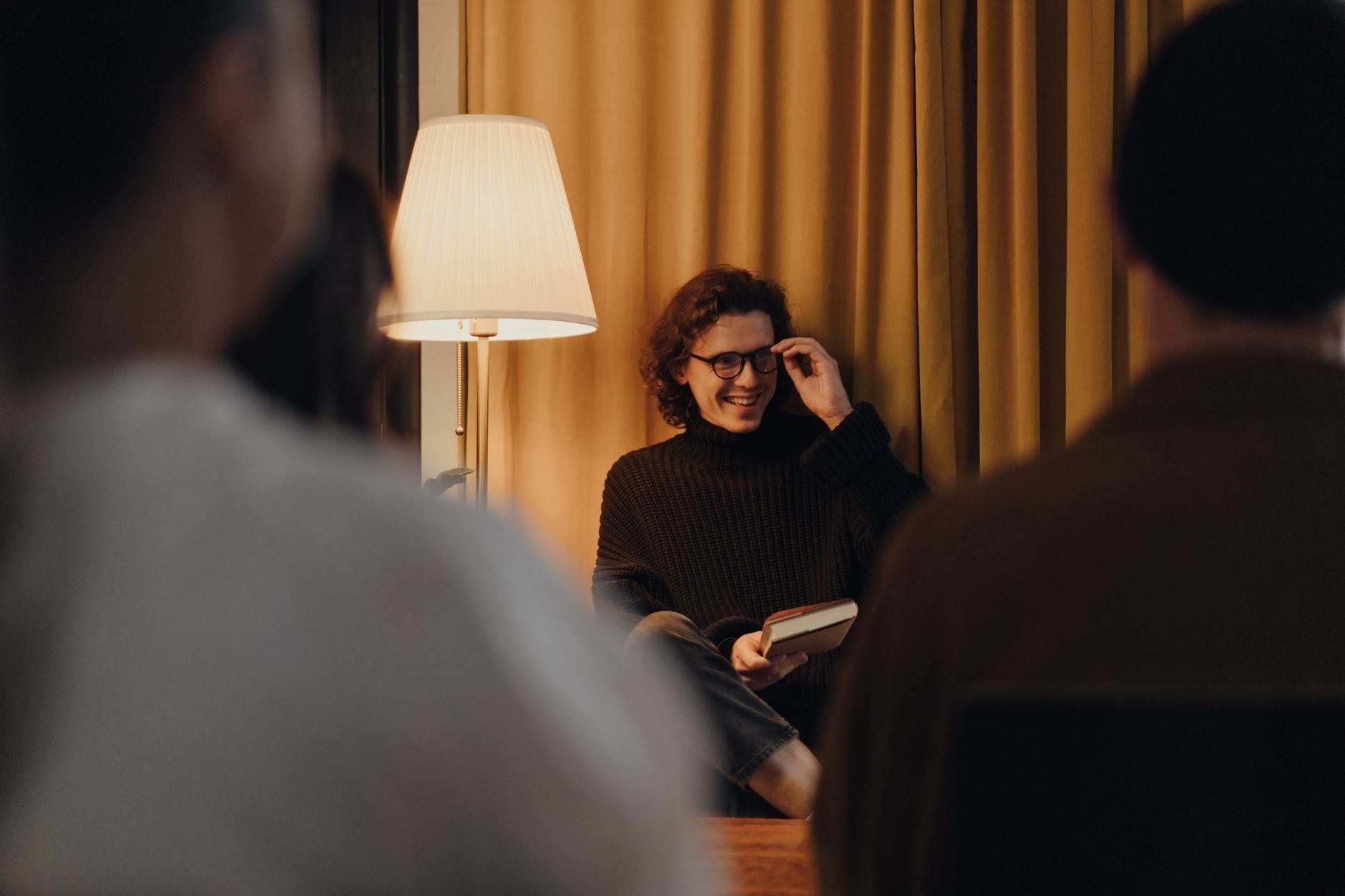 Warm indoor book reading event with interactive discussion. Cozy atmosphere.