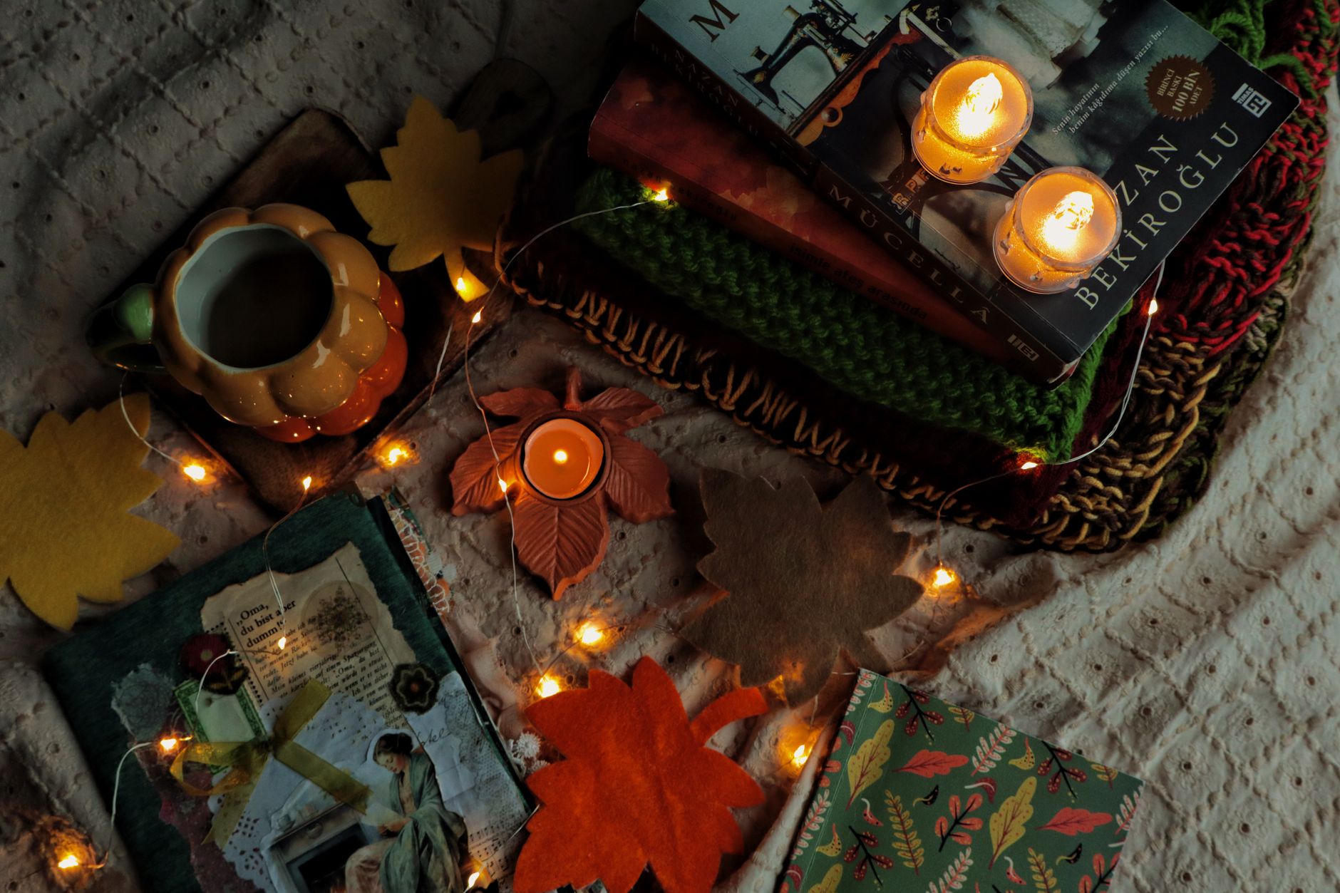 Warm autumn scene with books, candles, and cozy decorations creating a relaxing atmosphere.