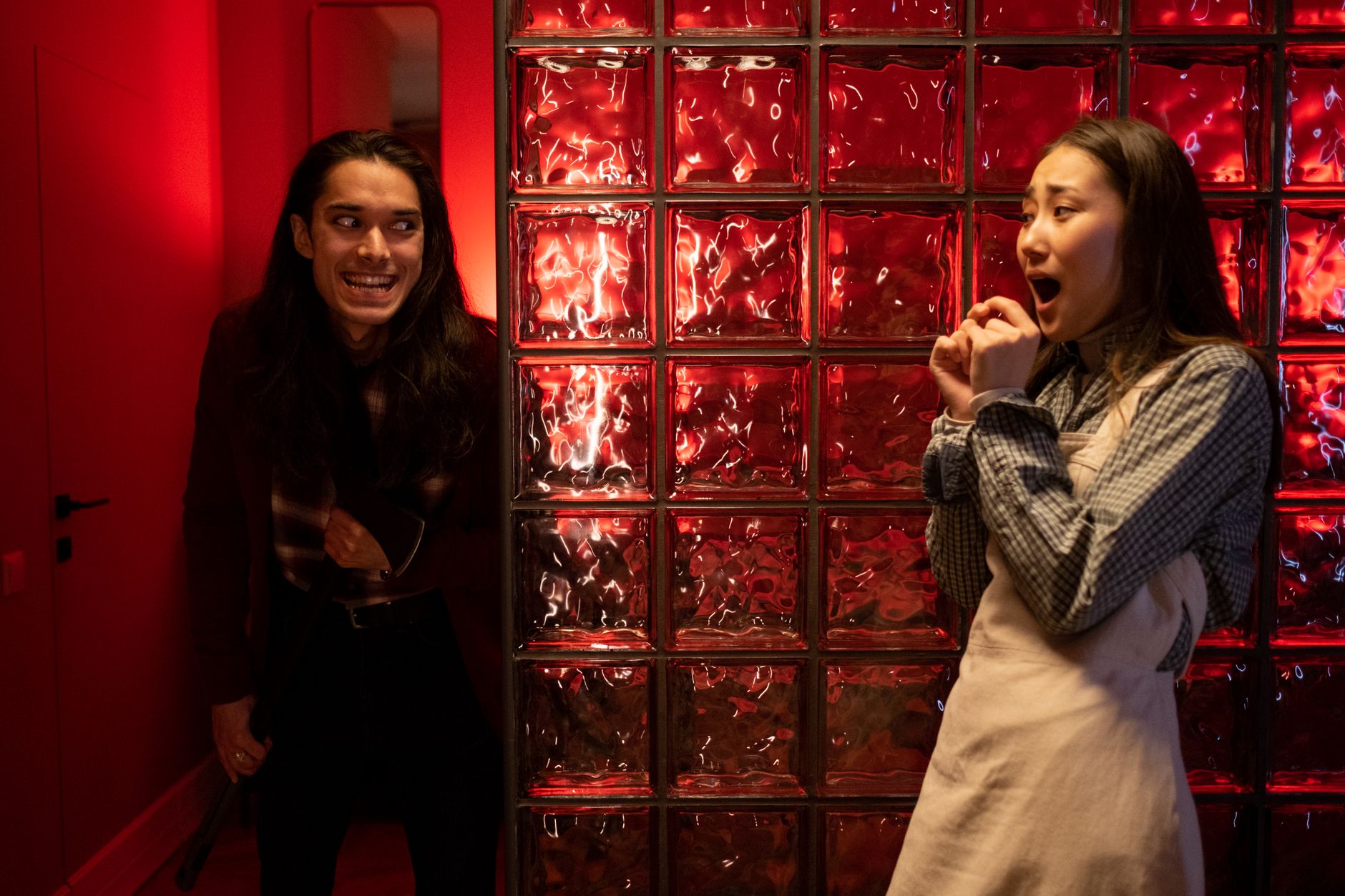 A dramatic indoor scene with two teenagers showcasing surprise and suspense.
