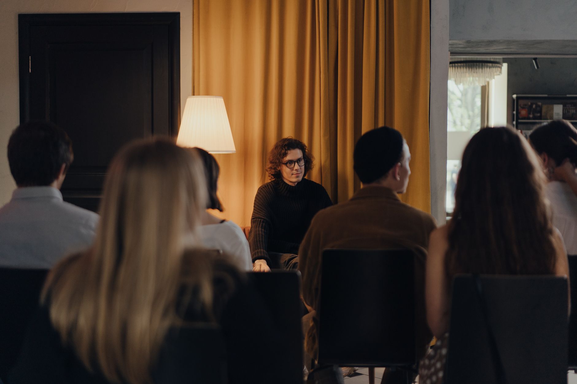 A writer engaging with an audience during a book discussion indoors.